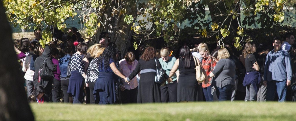 Evacuated workers pray on the San Bernardino Golf Course across the street from a mass shooting at the Inland Regional Center in San Bernardino, Calif., on Wednesday, Dec. 2, 2015. (Gina Ferazzi/Los Angeles Times/TNS) ORG XMIT: 1177505